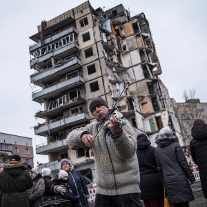 Virginie Nguyen Hoang. Ukraine, Dnipro, 2023/01/22 : Un homme joue du violon après le service par des prêtres orthodoxes pour rendre hommage aux victimes d’une frappe de missiles à Dnipro devant le bâtiment qui a été touché il y a 9 jours. Selon les autorités ukrainiennes, le bâtiment a été touché par un missile russe Kh-22 (missile anti-navire à longue portée) qui a anéanti 70 appartements en quelques secondes. Au moins 46 personnes ont été tuées, 11 sont toujours portées disparues. © Virginie Nguyen Hoang